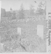 SA0355 - Photo showing tombstones and a fence with a hill in the distance. Identified on the back where there is an advertisement for other views in the stereo card series.